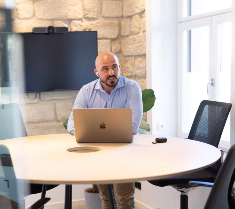 NOVUM DIGITAL® Kollege am Laptop im Meetingraum der Villa Nova