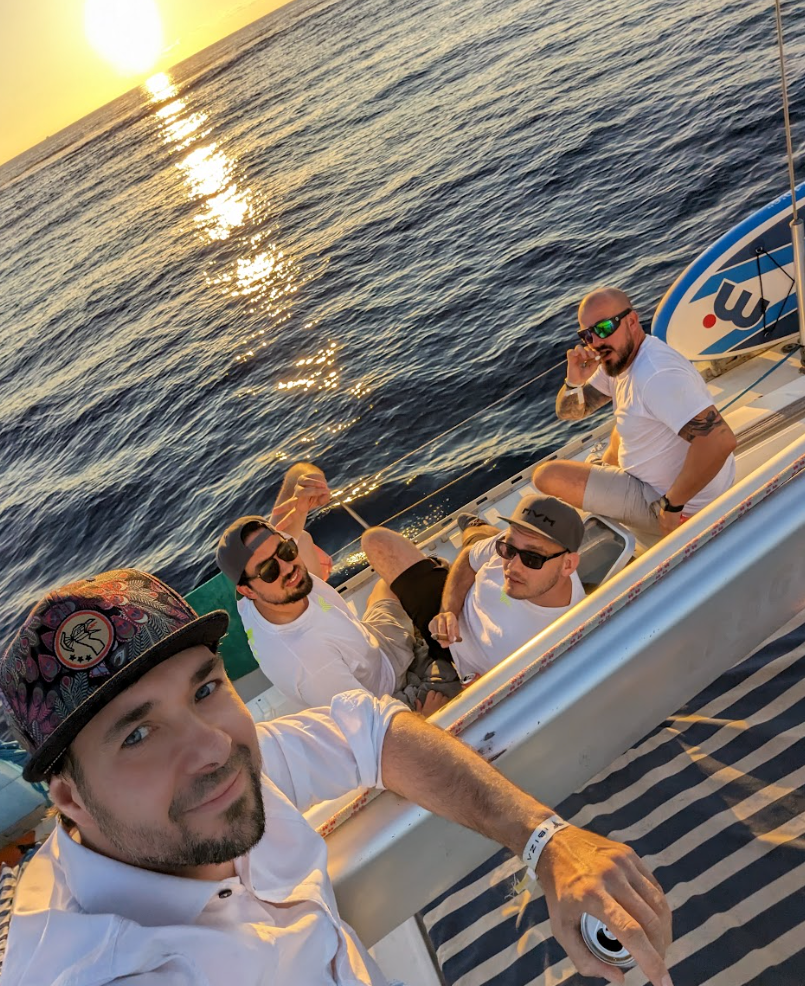 Team auf dem Segelboot bei Sonnenuntergang